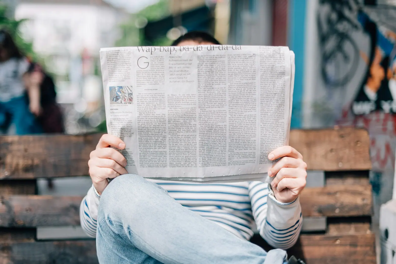 Printed newspapers beside a tablet showing digital publishing